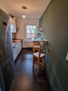 a small kitchen with a table and a refrigerator at Haus Elke in Blankenrath