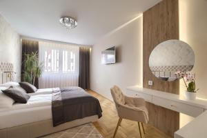 a bedroom with a bed and a desk and a mirror at Apart-Wita in Wadowice