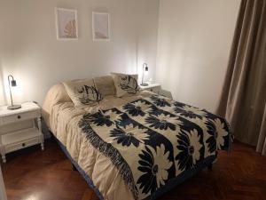 ein Schlafzimmer mit einem Bett mit einer schwarzen und weißen Decke in der Unterkunft Alquiler Temporal Departamento centrico y confortable en Mendoza in Mendoza