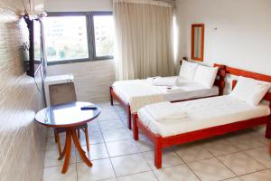 a hotel room with two beds and a table at River Class Hotel in Petrolina