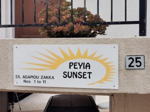 ein Schild für ein Resort mit einem Schild für einen Sonnenstich in der Unterkunft Peyia Sunset in Peyia