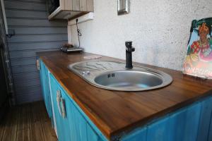 Łazienka wyposażona jest w umywalkę z drewnianym blatem. w obiekcie Zapat Lodge w mieście Baie-Mahault