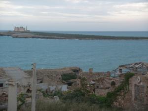 an island in the ocean with a castle in the distance at Casa Vacanze Antares in Portopalo