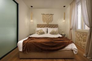 a bedroom with a large bed with a brown blanket at Apartment City Walls in Old Town of Rovinj in Rovinj