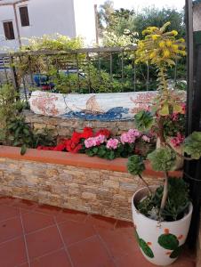 a bunch of flowers in a pot on a brick wall at VILLA CORALLINA in San Vito lo Capo