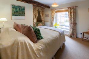 a bedroom with a large bed and a window at Bluebell Cottage - Norfolk Cottage Agency in Burnham Market