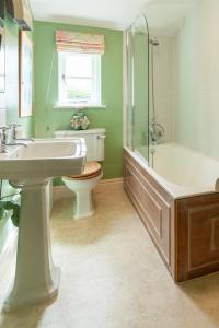 a bathroom with a sink and a tub and a toilet at Bluebell Cottage - Norfolk Cottage Agency in Burnham Market
