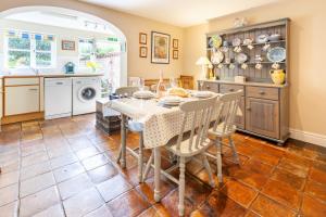 a kitchen and dining room with a table and chairs at Bluebell Cottage - Norfolk Cottage Agency in Burnham Market