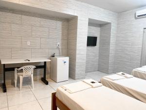 Habitación con escritorio y nevera. en River Class Hotel, en Petrolina