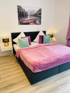 ein Schlafzimmer mit einem großen Bett mit bunten Kissen in der Unterkunft Prime Host Balcony Apartment in Karlsruhe