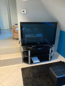 a flat screen tv sitting on a entertainment center at A proximité des plages Normandes in Cairon