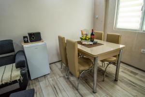 una mesa de comedor con sillas y una botella de vino en Apartman Trijumf, en Bajina Bašta