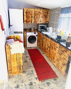 a kitchen with a washing machine and a red rug at Lovely newly refurbished, 1 bedroom top floor apartment with sea views, fast WI-FI CABLE TV and Netflix in Ribeira Brava