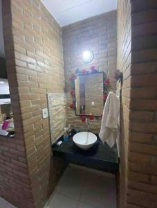 a bathroom with a sink and a brick wall at Casa agradável em um condomínio na barra do sana. in Sana