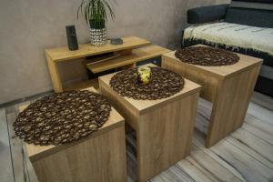 a living room with three tables with a vase on them at Apartman Trijumf in Bajina Bašta