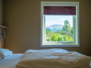 a bedroom with a window with a mountain view at Krokstrand Fjellpark AS in Storforshei