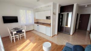 a kitchen and a living room with a table and chairs at Apartament Amber in Sopot