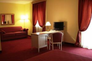 a hotel room with a desk with a television and a couch at Hotel Il Duca Del Sannio in Agnone