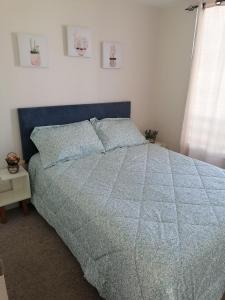 a bedroom with a bed with a blue comforter and a window at Dpto Bordemar 2 in Las Cruces +14 photos