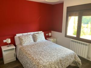 1 dormitorio con cama y pared roja en Apartamento Rural 2 Casa Bergua, en Arguis