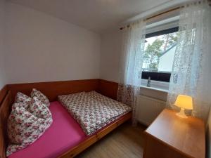 a small bedroom with a bed and a window at Sosnowka in Pobierowo