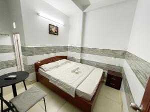 a small bedroom with a bed and a table at Huy Hoàng Hotel in Ho Chi Minh City