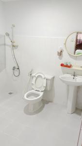 a white bathroom with a toilet and a sink at Huy Hoàng Hotel in Ho Chi Minh City