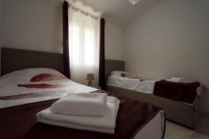 two beds in a room with a window and towels at Eco Village experience - Skadar Lake in Virpazar