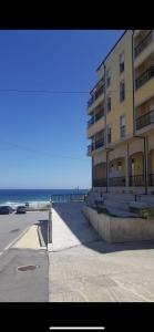 a large building next to a beach with the ocean at OKTHEWAY MALPICA in Malpica