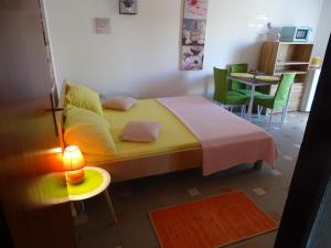 1 dormitorio con 1 cama, mesa y sillas en Apartments Šime, en Dinjiška