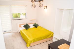 um quarto com uma cama amarela num quarto branco em Zibi i Pod Topolami em Łazy