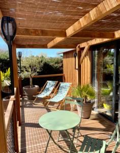 a patio with chairs and a table on a deck at Cottage cosy Bassin d'Arcachon in La Teste-de-Buch