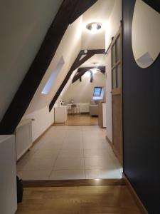 un pasillo en el ático con paredes blancas y techo en La Manécanterie, en Bourges