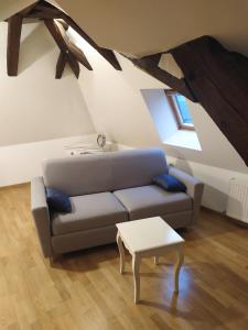 sala de estar con sofá y mesa en La Manécanterie, en Bourges