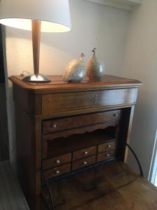 a table with two vases on it with a lamp on it at Charmante maison VintageCorner in Saint-Blaise