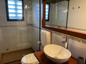 a bathroom with a sink and a toilet and a mirror at Posada de la Viuda in Punta Del Diablo