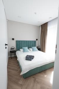パランガにあるPajūrio Gintaro apartamentaiの緑のヘッドボードが付いた大きなベッドのある寝室