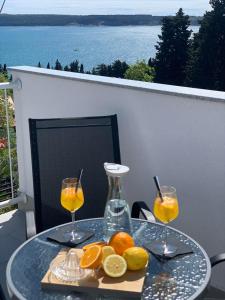 einen Tisch mit zwei Gläsern Orangensaft und Zitronen in der Unterkunft Apartmaji Amitis in Portorož