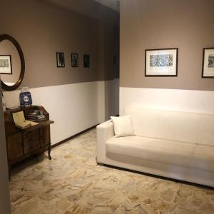 a living room with a white couch and a table at Apartment Ponte delle Nazioni in Parma