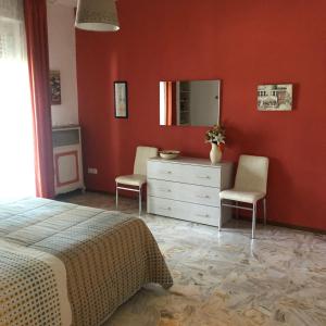 a bedroom with a bed and a dresser and a mirror at Apartment Ponte delle Nazioni in Parma