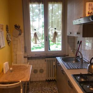a kitchen with two windows and a sink and a counter at Apartment Ponte delle Nazioni in Parma