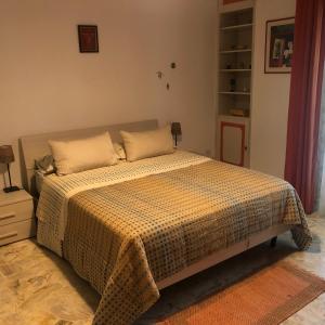a bedroom with a bed with a checkered blanket at Apartment Ponte delle Nazioni in Parma