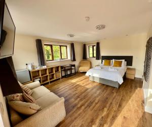 a bedroom with a bed and a couch at Lillypool Farm in Shipham