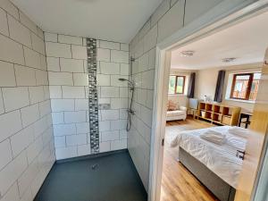 Un baño con ducha y una cama en una habitación. en Lillypool Farm, en Shipham 9 fotos más