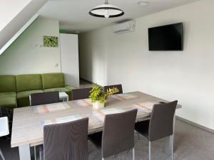 a dining room with a table and a green couch at Apartments Hradný Mur in Bojnice
