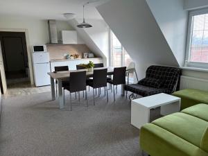 Apartments Hradný Mur في بوينيتسا: غرفة معيشة مع طاولة وكراسي ومطبخ