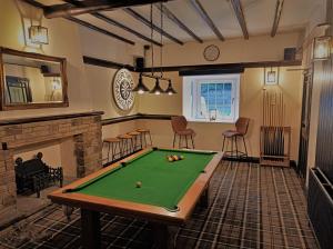 a living room with a pool table and a fireplace at Spring Grove B&B in Huddersfield