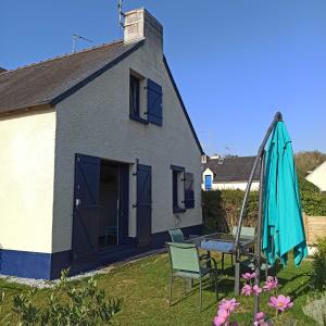 een huis met een patio en een parasol bij Ty Calouenn, la plage à pied in Le Pouldu