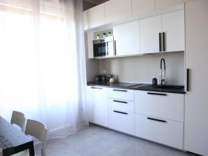 a white kitchen with a sink and a microwave at Le Case di Sonia TRE GEMME Zaffiro Fucecchio in Fucecchio