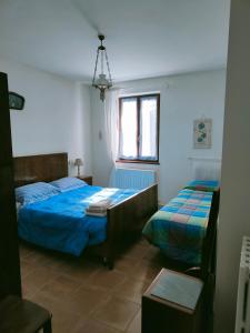 een slaapkamer met 2 bedden en een raam bij I Duchi Pellegrini in Santa Maria Nuova